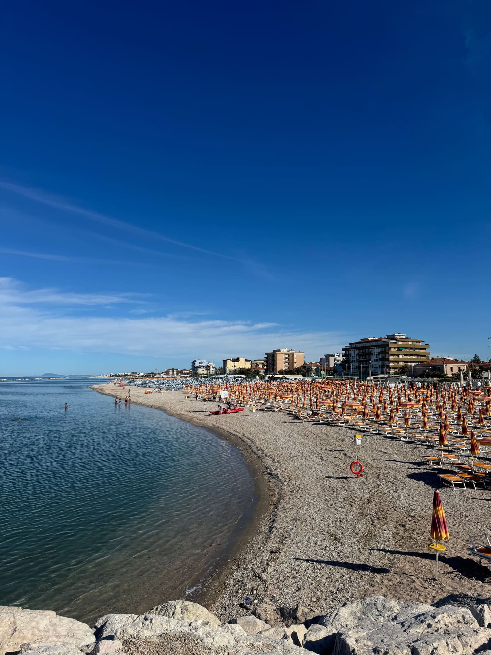 la spiaggia di Sassonia piena di ombrelloni, con la città dietro