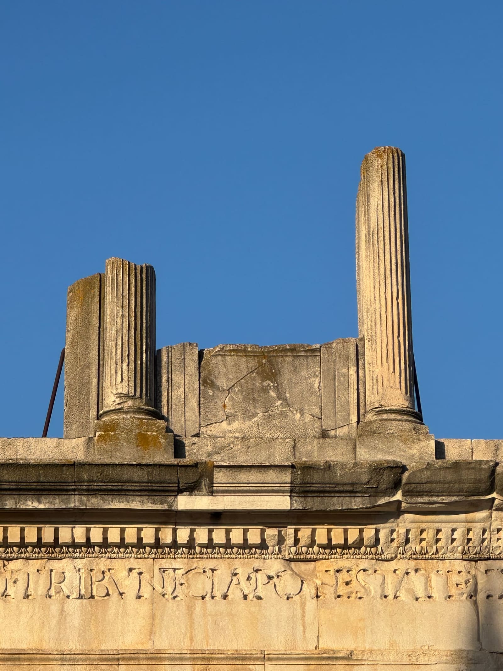 l'iscrizione dedicata ad Augusto sull'attico dell'arco, con le colonne mozzate sopra