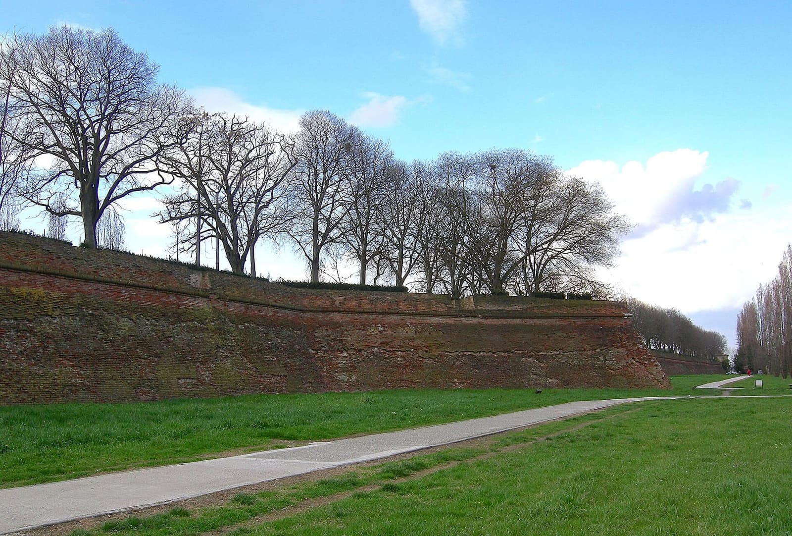 le mura di Ferrara vicino a Porta San Giovanni, con il sentiero nel vallo e gli alberi spogli