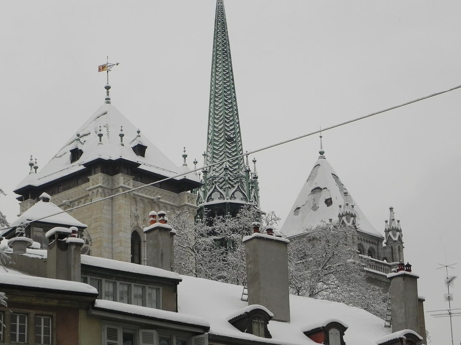le torri e la guglia di Saint-Pierre con la neve, sopra i tetti della città vecchia