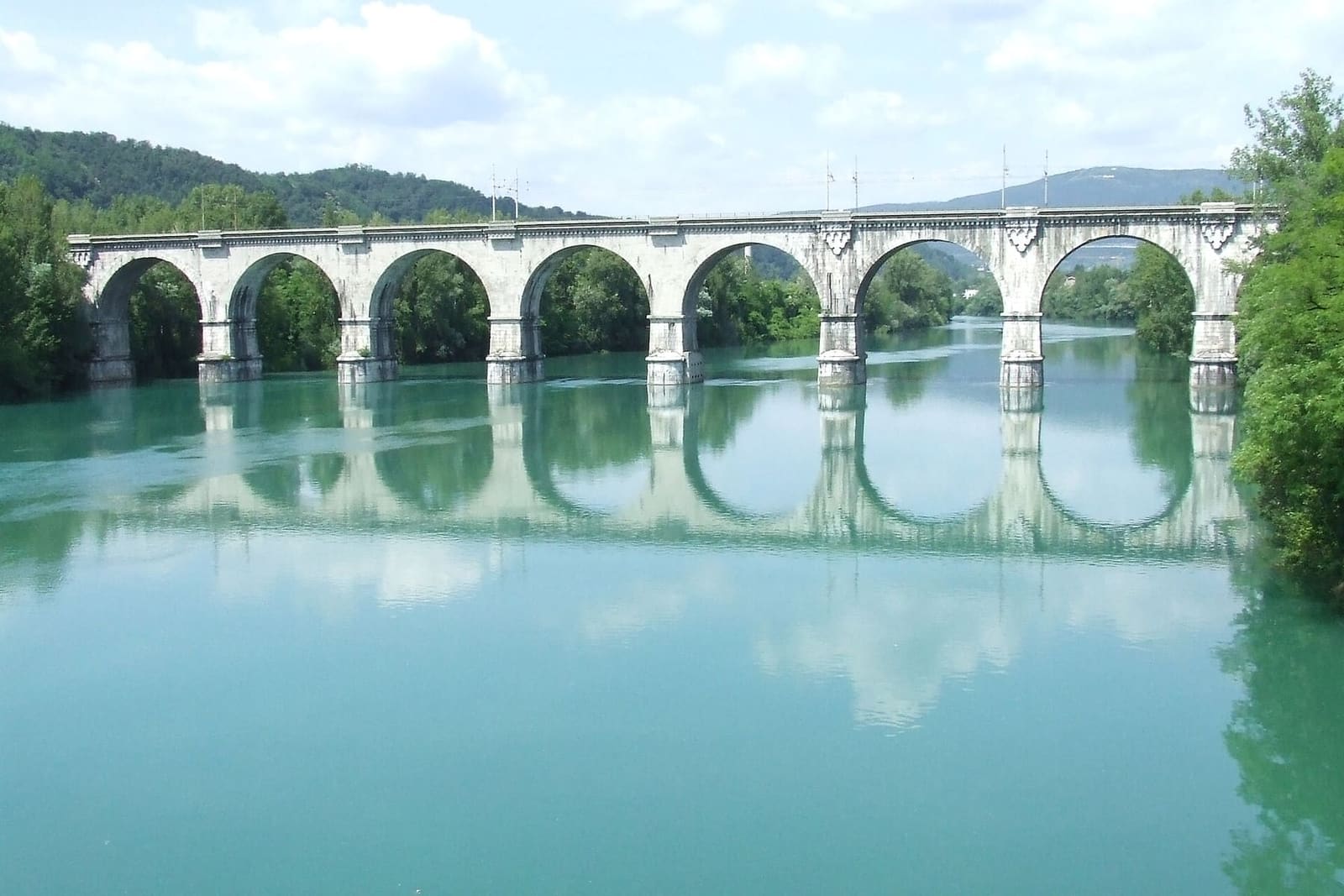 der grüne Isonzo unter den Bögen der Eisenbahnbrücke in Gorizia