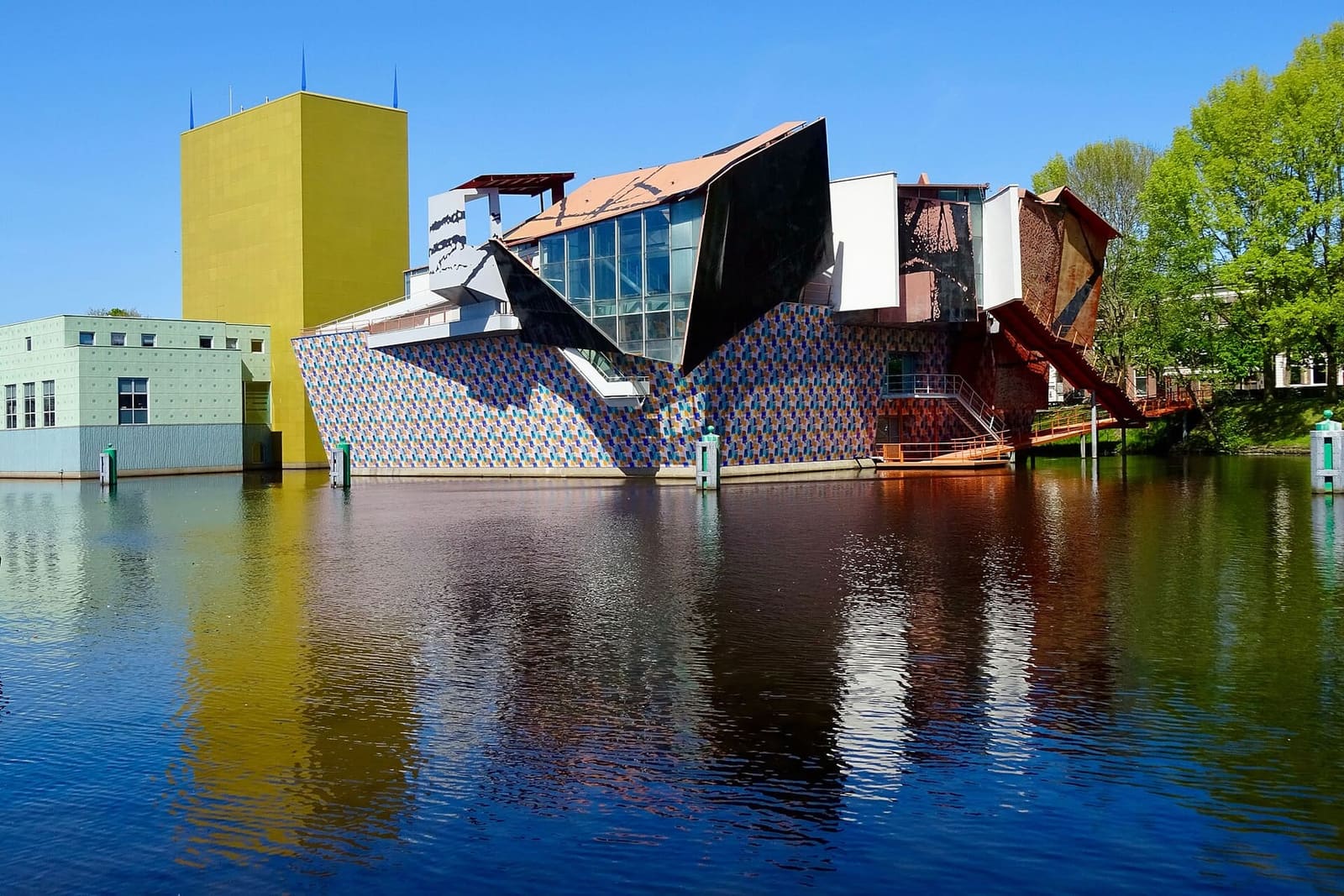 il Groninger Museum sull'acqua, con la torre gialla e il padiglione decostruttivista