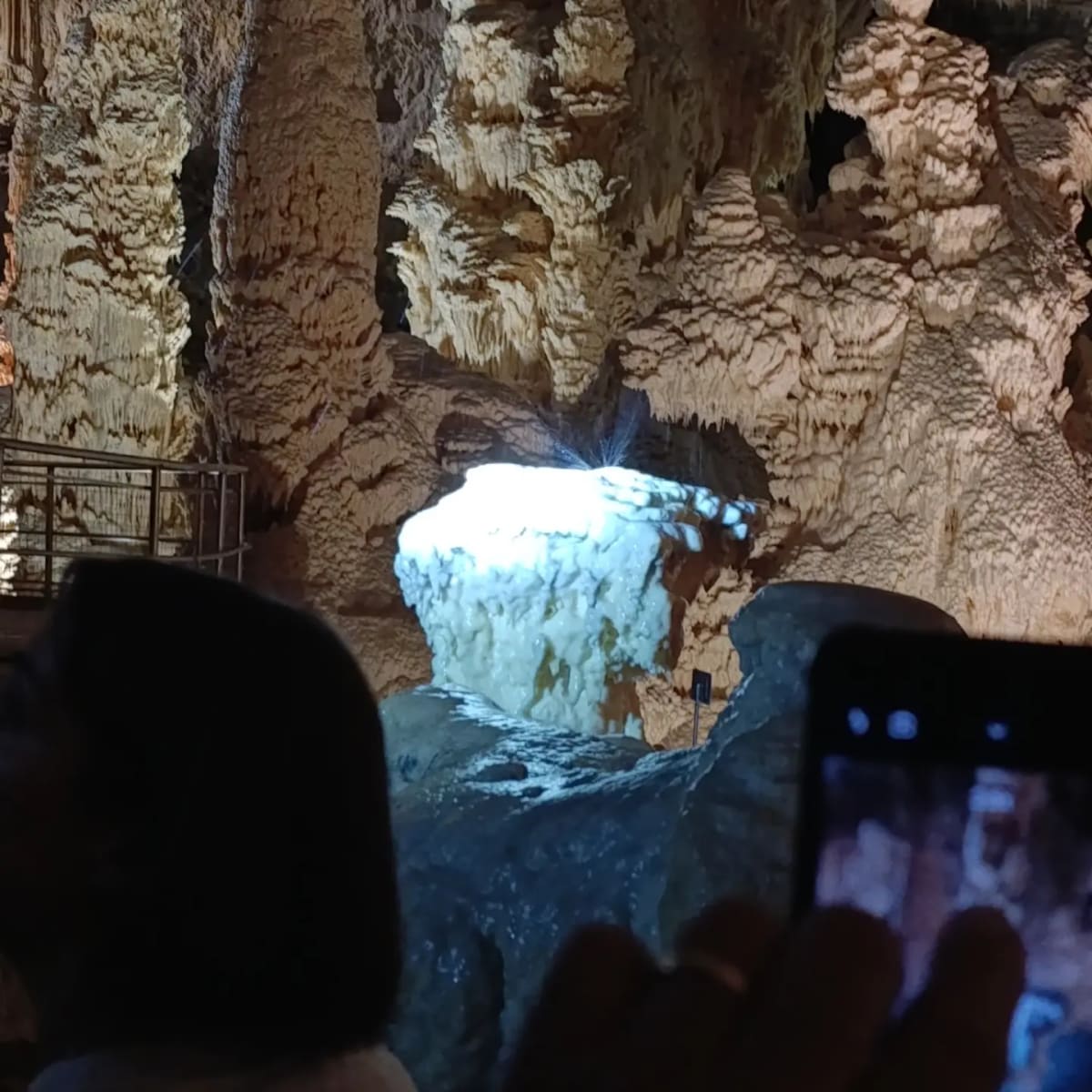 il blocco di calcite bianca dietro un telefono alzato a filmarlo: metà delle fotografie qui dentro vengono così