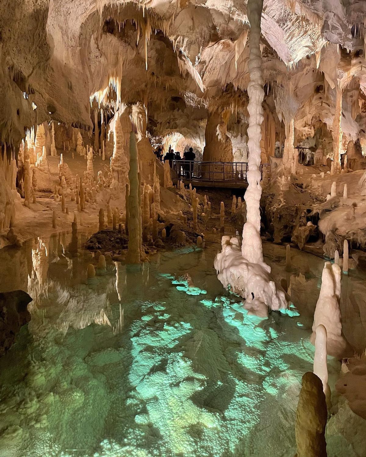 l'acqua illuminata da sotto diventa verde smeraldo, la grande colonna bianca ci finisce dentro, e sul ponte in alto si vede il gruppo che passa