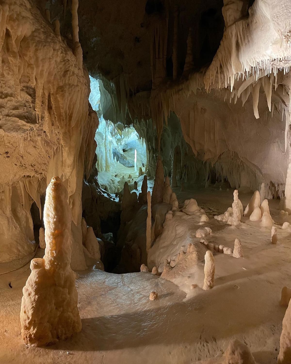 una stalagmite alta quasi come una persona, e dietro il pavimento coperto di coni piccoli tutti uguali