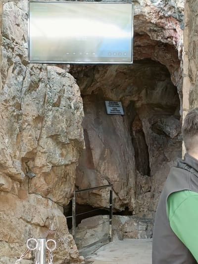 l'imbocco della grotta, con il cartello delle pitture rupestri paleolitiche