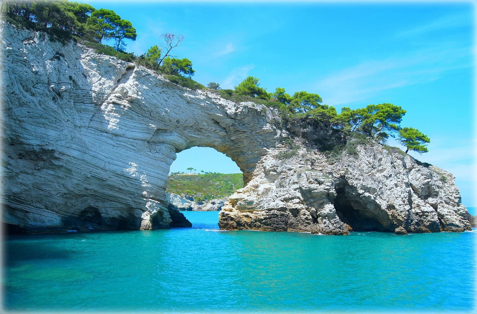 das Architiello vom Meer aus gesehen, mit dem türkisfarbenen Wasser unter dem Bogen