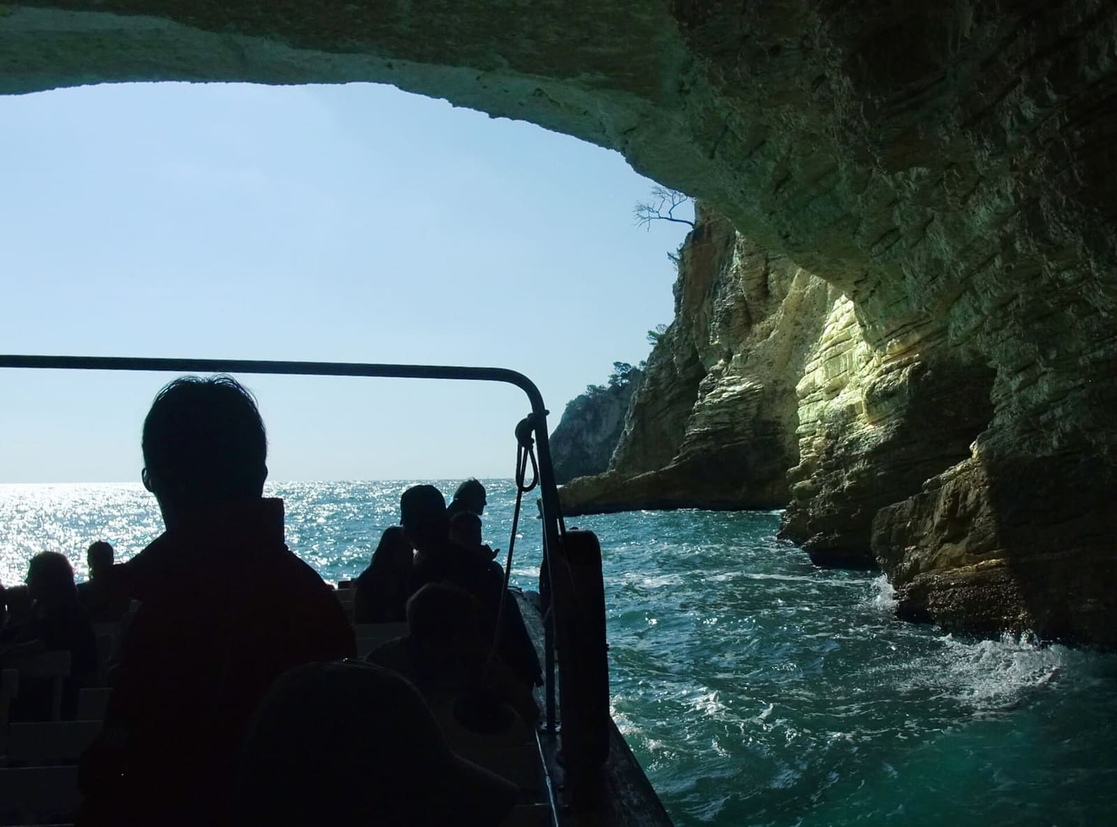 die Fahrgäste unter dem Gewölbe einer Grotte, im Gegenlicht