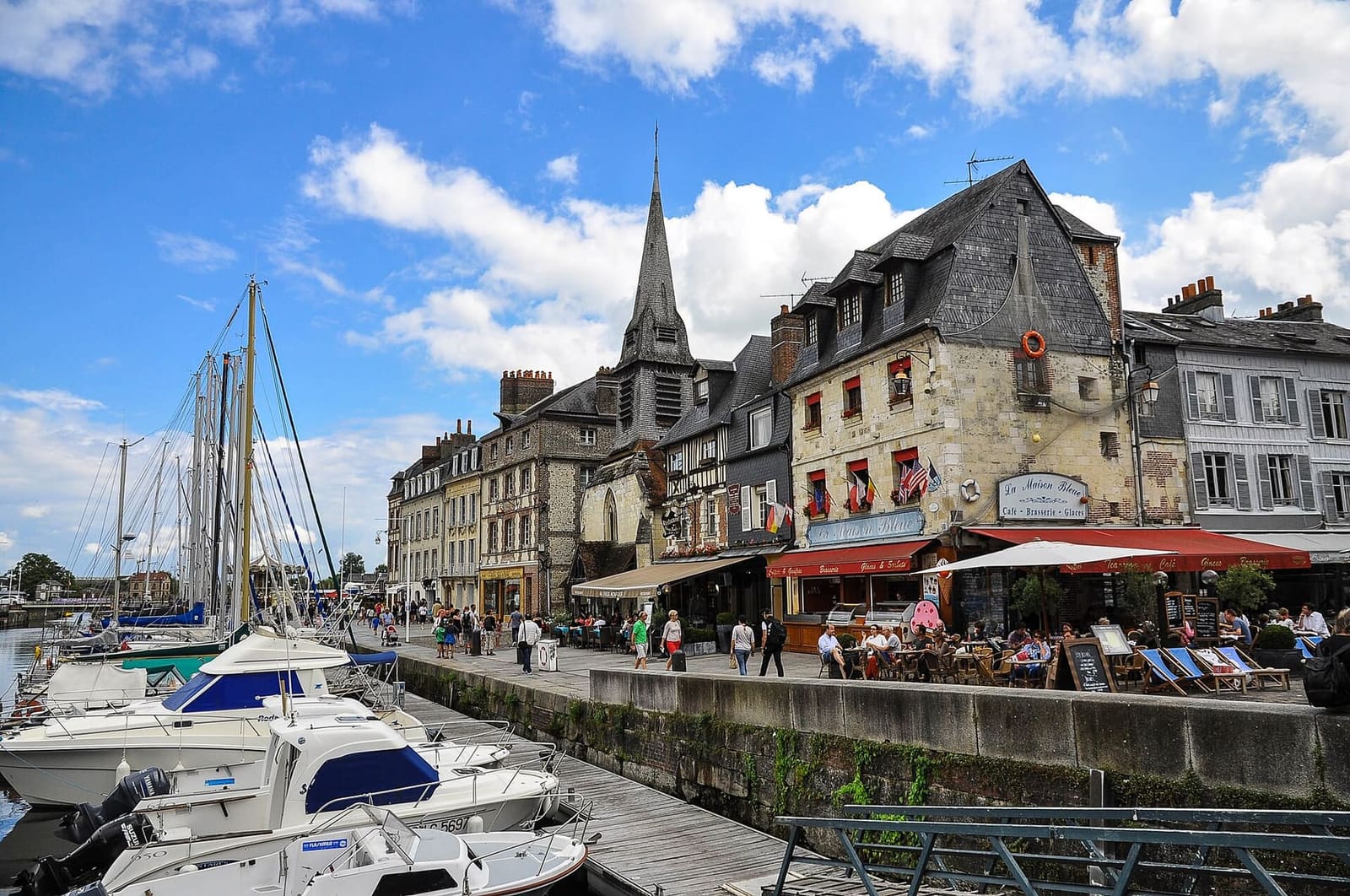 der Clocher Sainte-Catherine hinter den Häusern am Vieux Bassin, mit Tischen auf dem Kai, im August