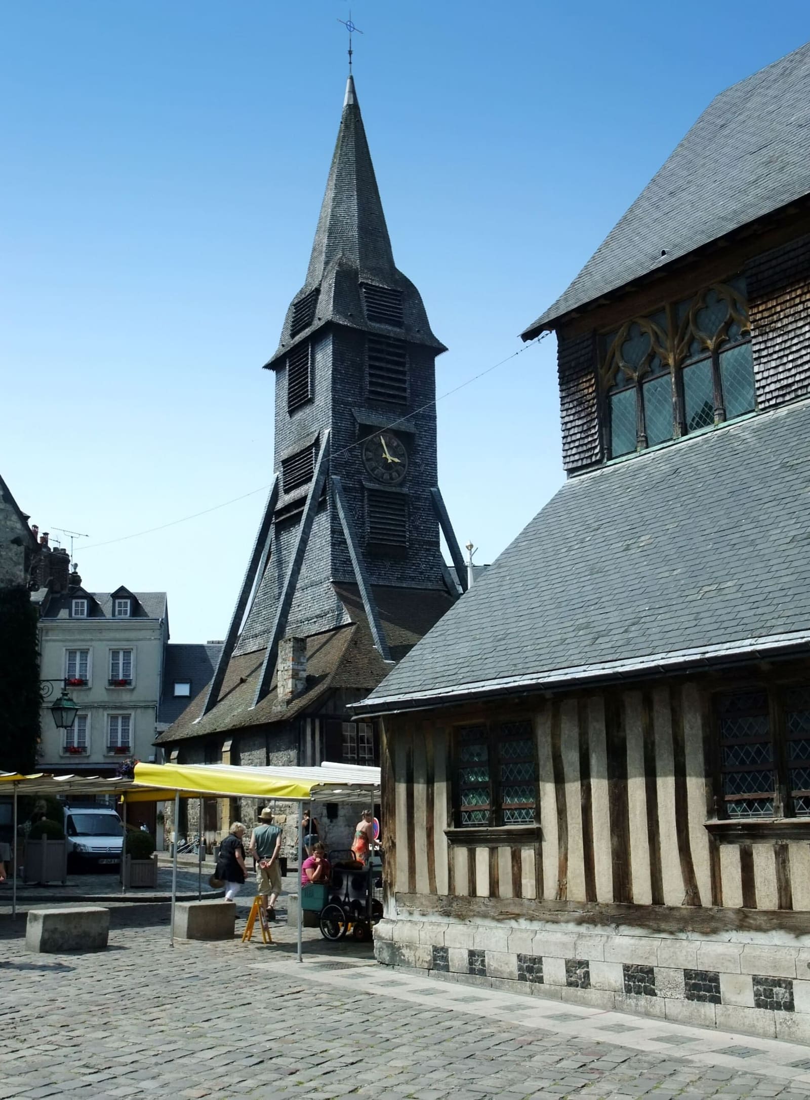 der Clocher Sainte-Catherine, der von der Kirche getrennte hölzerne Glockenturm, darunter Marktstände, im Juli