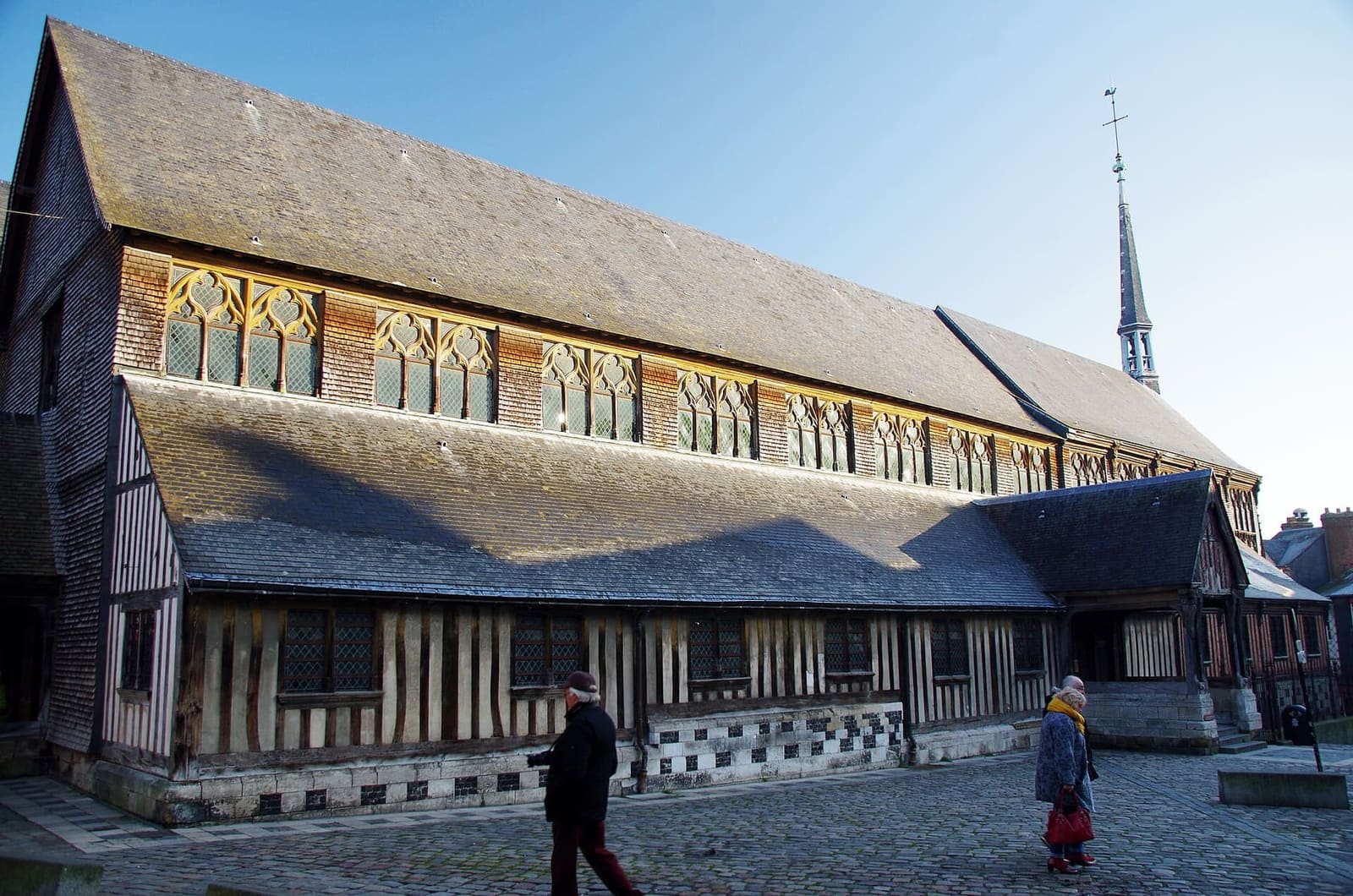 die Längsseite der Église Sainte-Catherine, mit Fachwerk im unteren Teil und doppeltem Schieferdach, im Februar