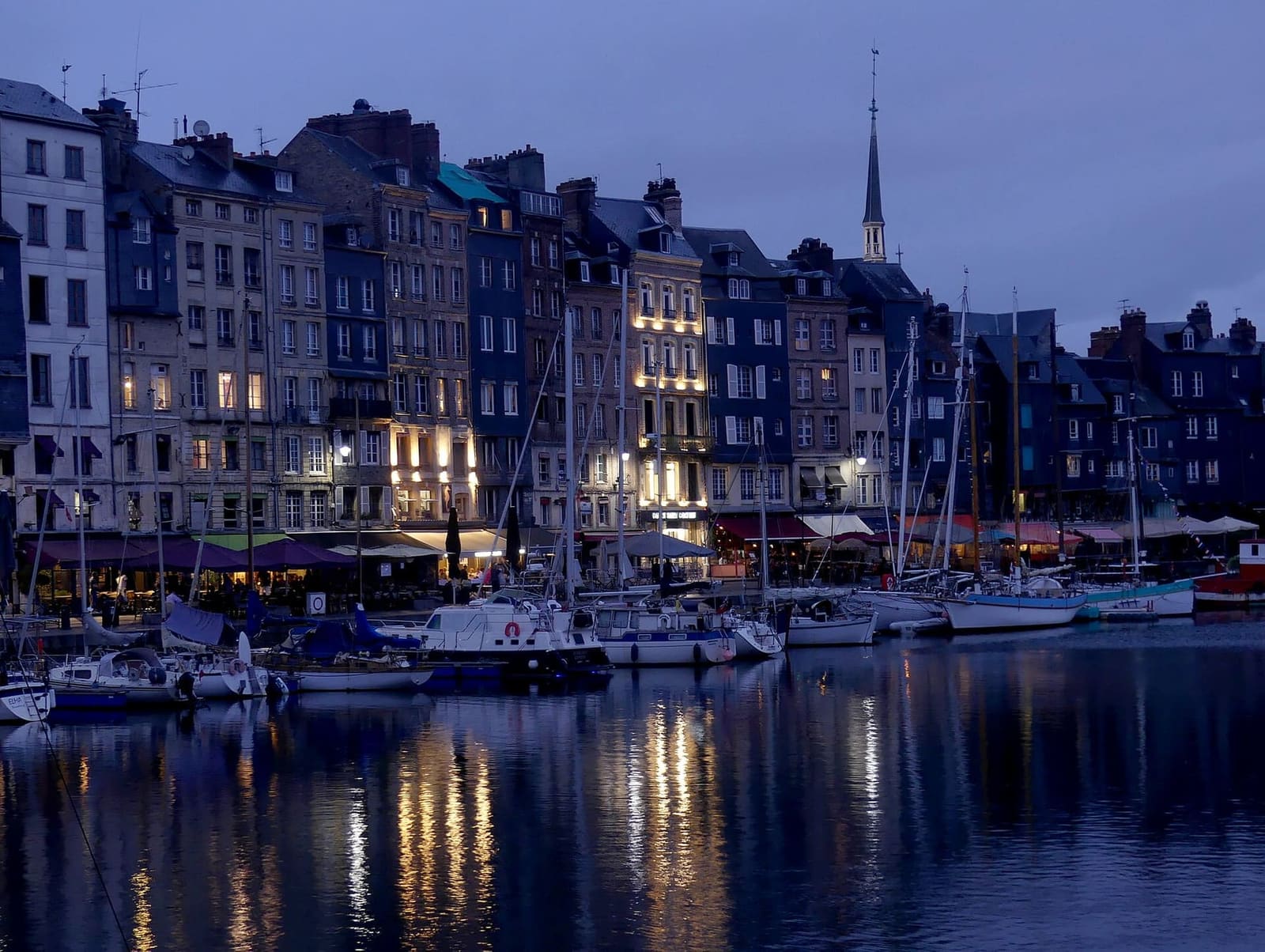 der Quai Sainte-Catherine in der Dämmerung, mit erleuchteten Fenstern und Booten im Vieux Bassin, im Juli