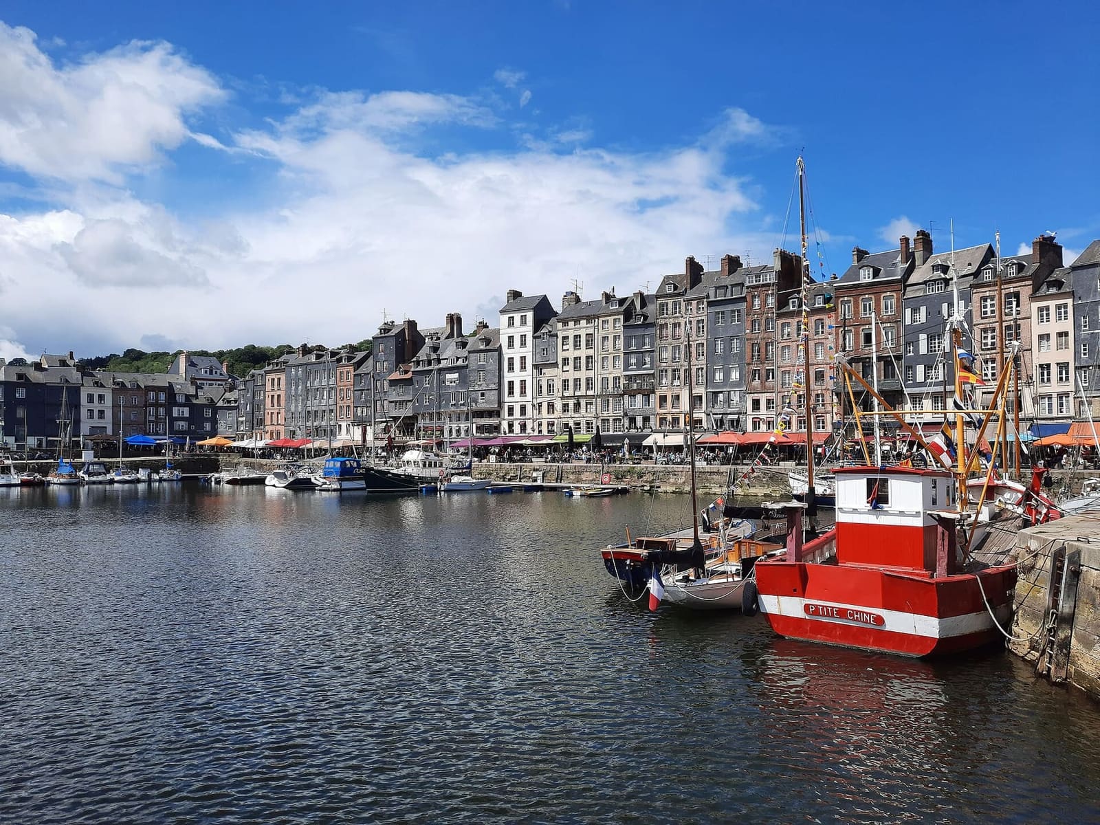 das Vieux Bassin mit den hohen Häusern des Quai Sainte-Catherine und einem roten Fischkutter am Liegeplatz, im Mai