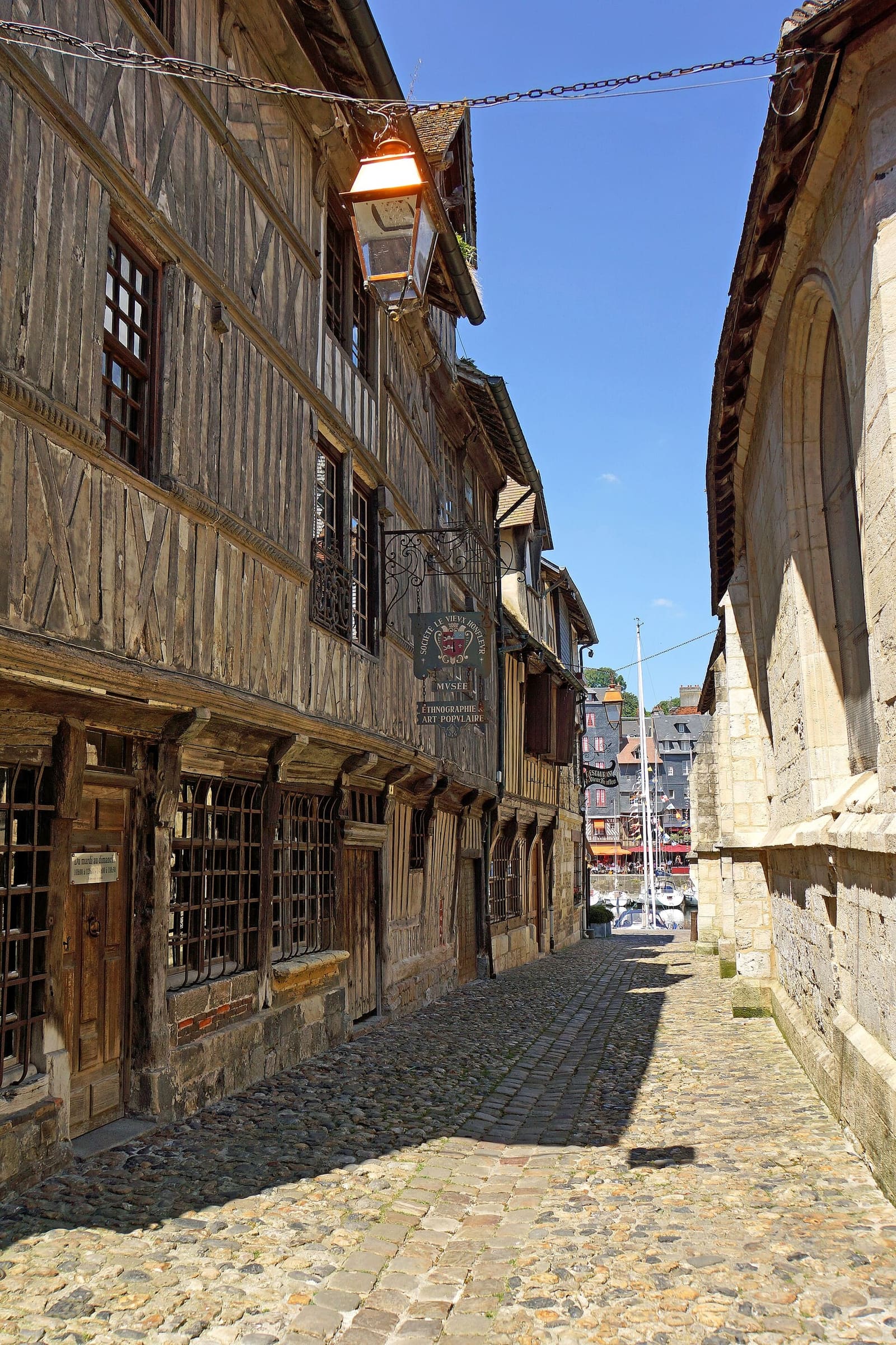 die Rue de la Prison, mit den vorkragenden Holzhäusern des Ethnografiemuseums und rechts der Église Saint-Étienne, im Juni