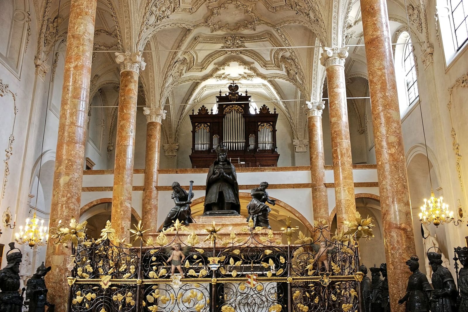 la tomba di Massimiliano nella Hofkirche, con l'imperatore inginocchiato e le statue di bronzo intorno