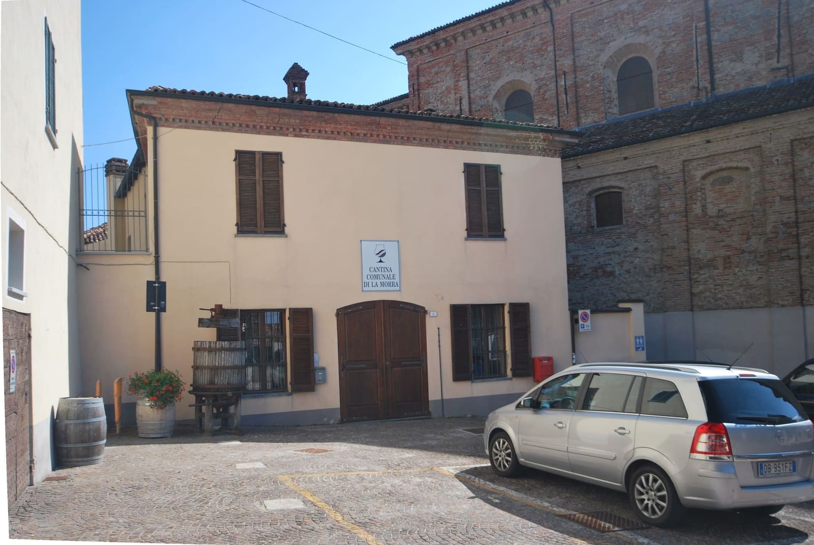 l'ingresso della Cantina Comunale, con il torchio e la botte davanti alla porta