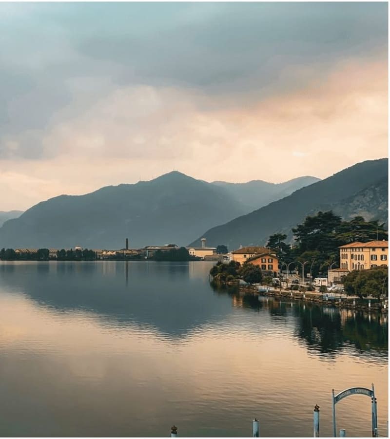 il ramo settentrionale del Sebino all'imbrunire, con le montagne in controluce e le case sulla riva destra