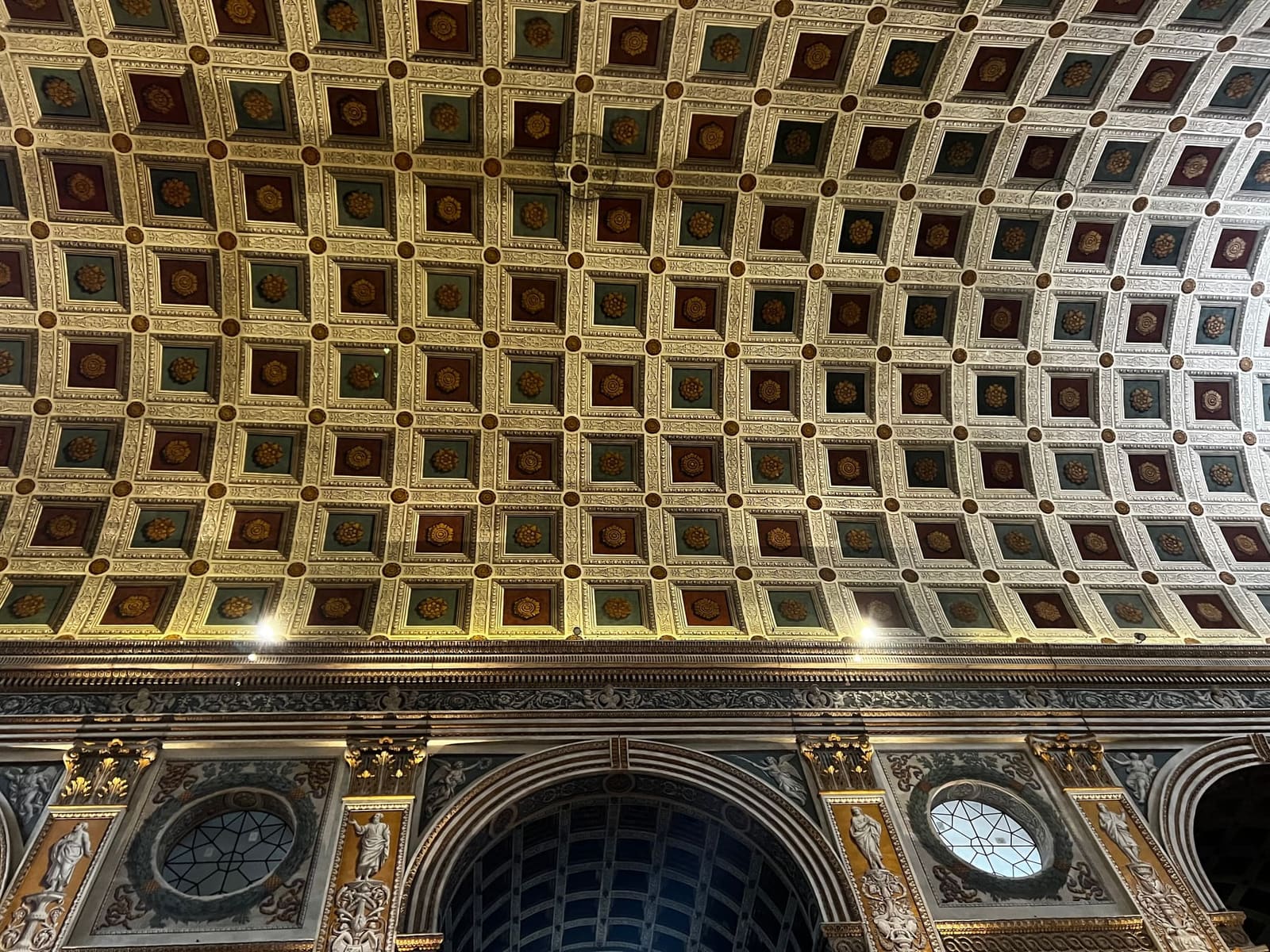 la volta a cassettoni dorati della basilica di Sant'Andrea sopra la navata, e le statue sulla parete