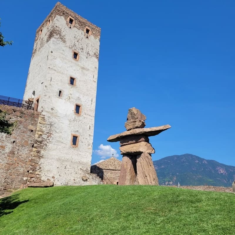 la torre bianca del castello e l'inukshuk di pietra sul prato davanti