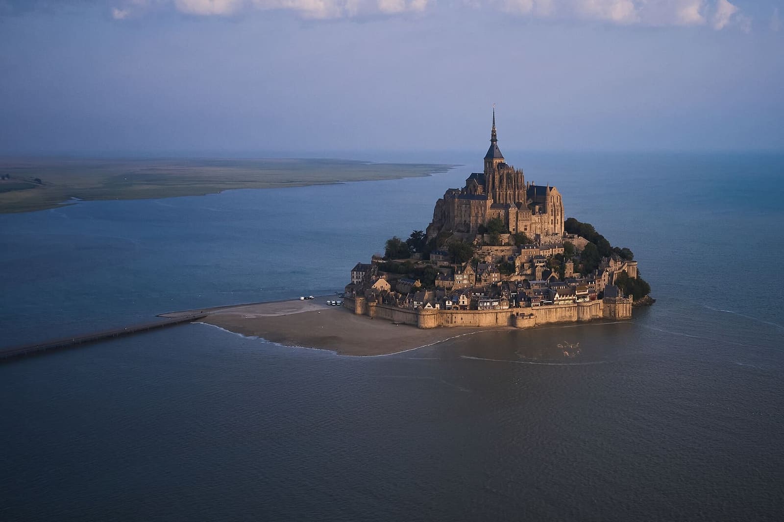 il Mont circondato dall'alta marea visto dall'alto, con la passerella che lo lega alla terraferma