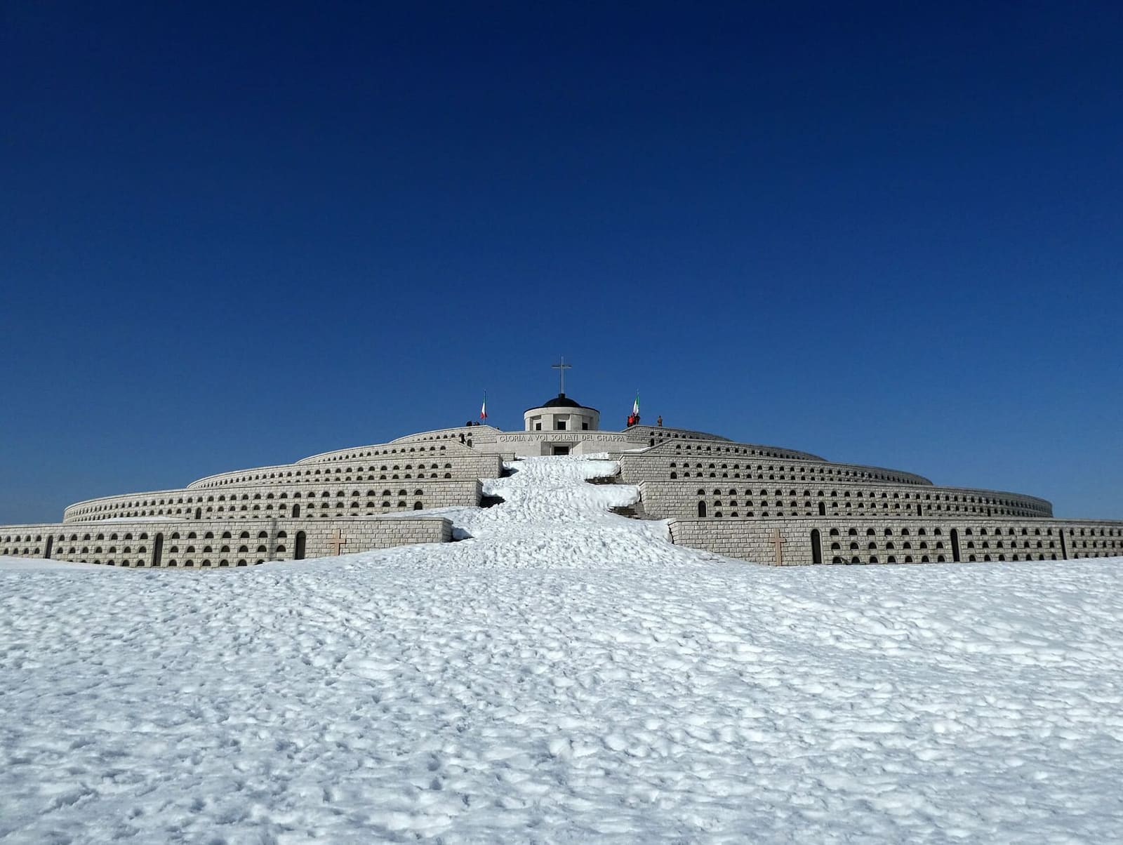 il Sacrario sotto la neve, con la scalinata bianca e il cielo blu di marzo