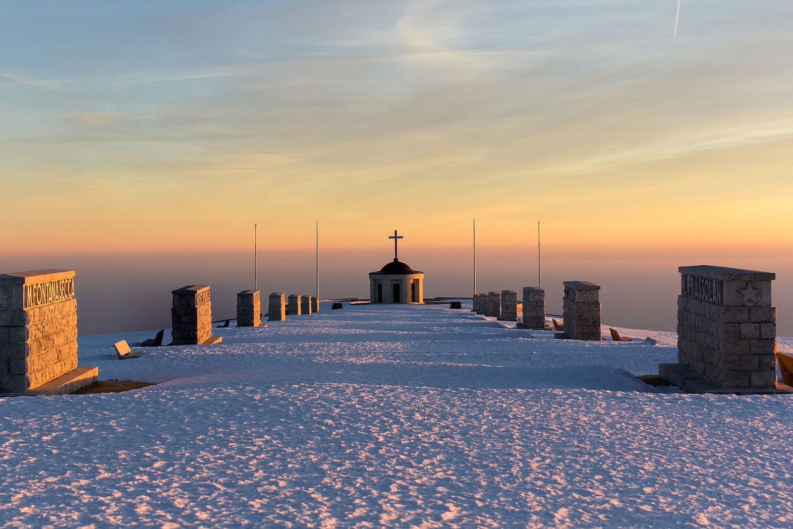 la Via Eroica coperta di neve al tramonto di gennaio, con la pianura sotto le nuvole