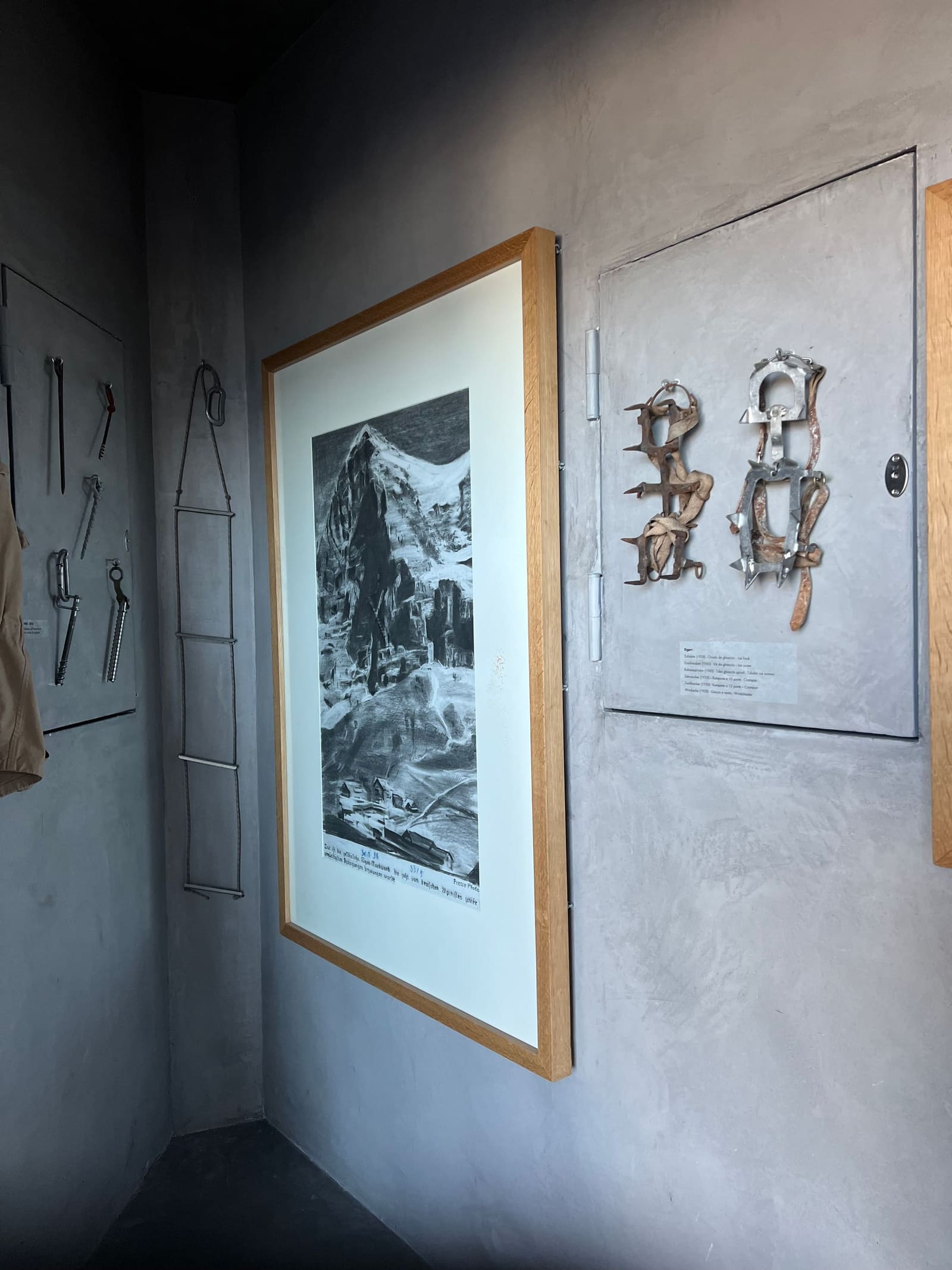 i ramponi di ferro alla parete, accanto al disegno a matita di una montagna