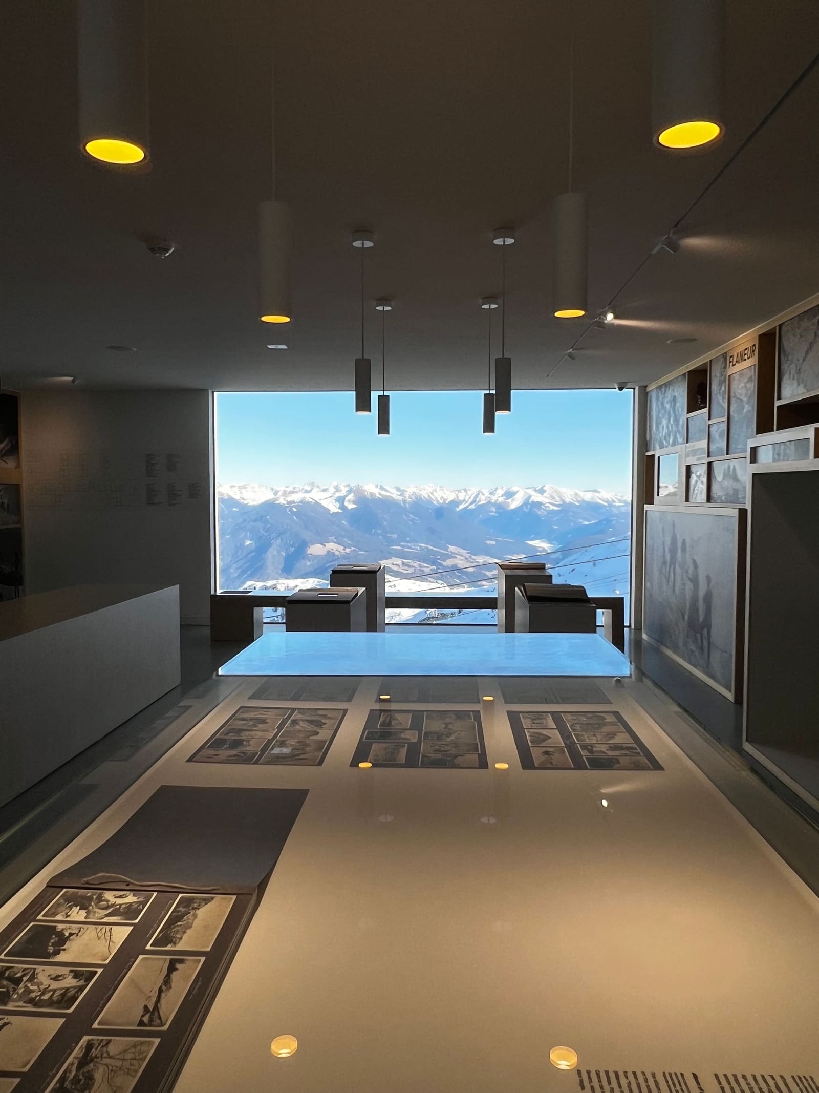 la sala dei tavoli luminosi del Lumen, aperta sulla vetrata e sulle montagne