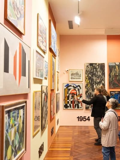 la sala del CAMeC con le annate scritte a parete e i quadri appesi fitti fino al soffitto