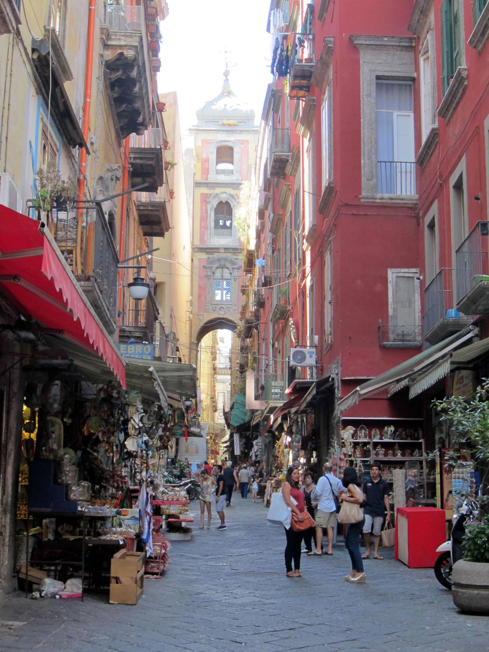 via San Gregorio Armeno con le botteghe dei presepi e il campanile sull'arco in fondo