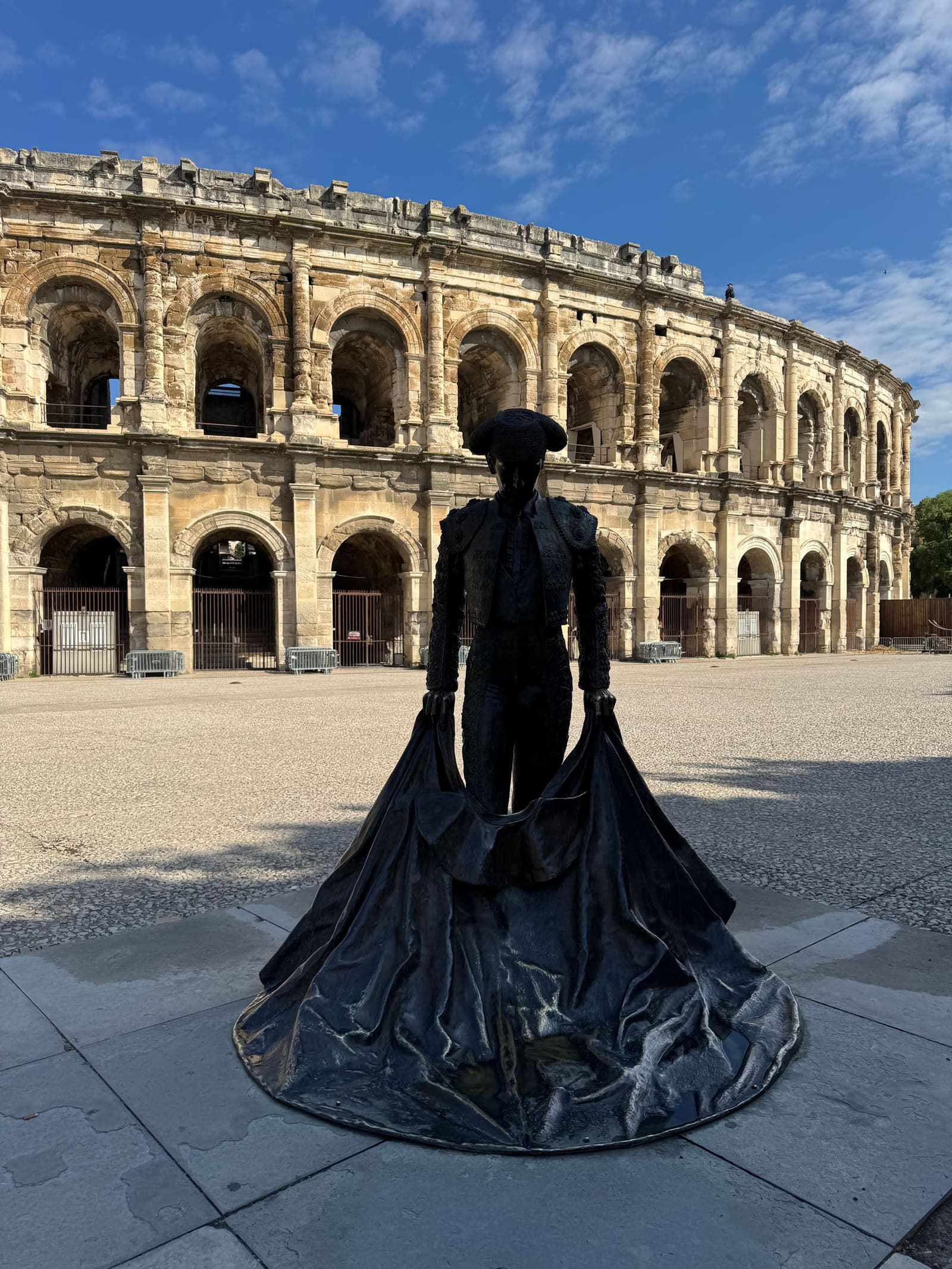 la statua di bronzo del torero Nimeño II davanti all'arena, con la cappa aperta a terra