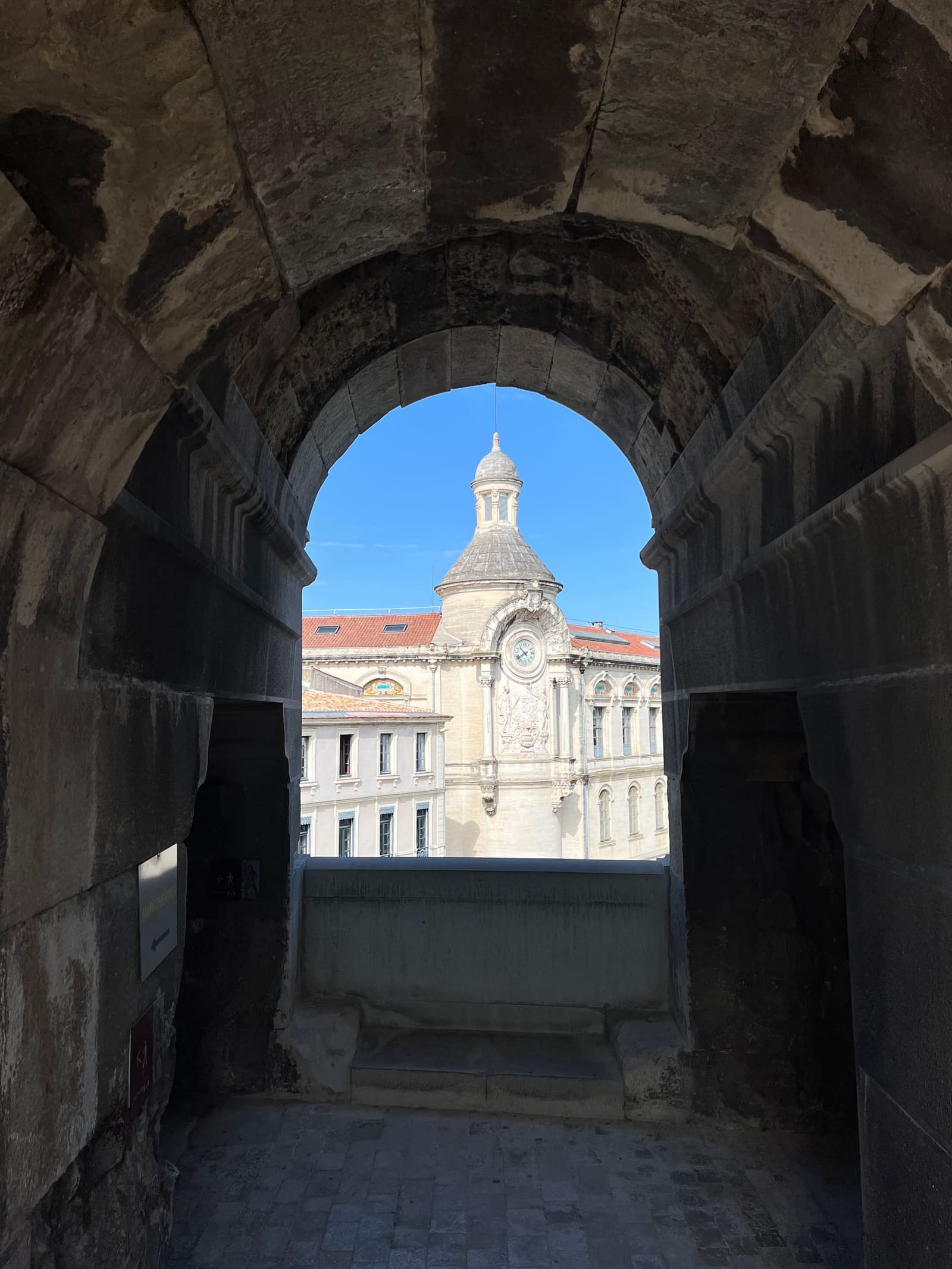 la torretta dell'orologio incorniciata da un'arcata dell'arena