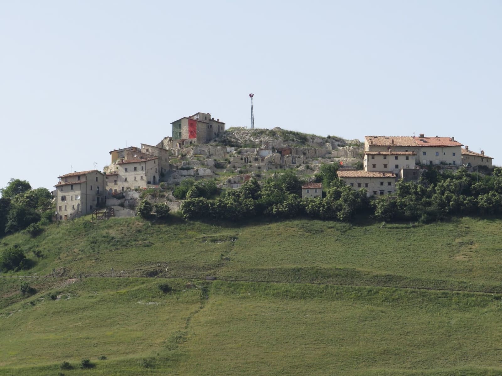 Castelluccio im Juni 2022, mit der Lücke, die das Erdbeben zwischen den Häusern hinterlassen hat