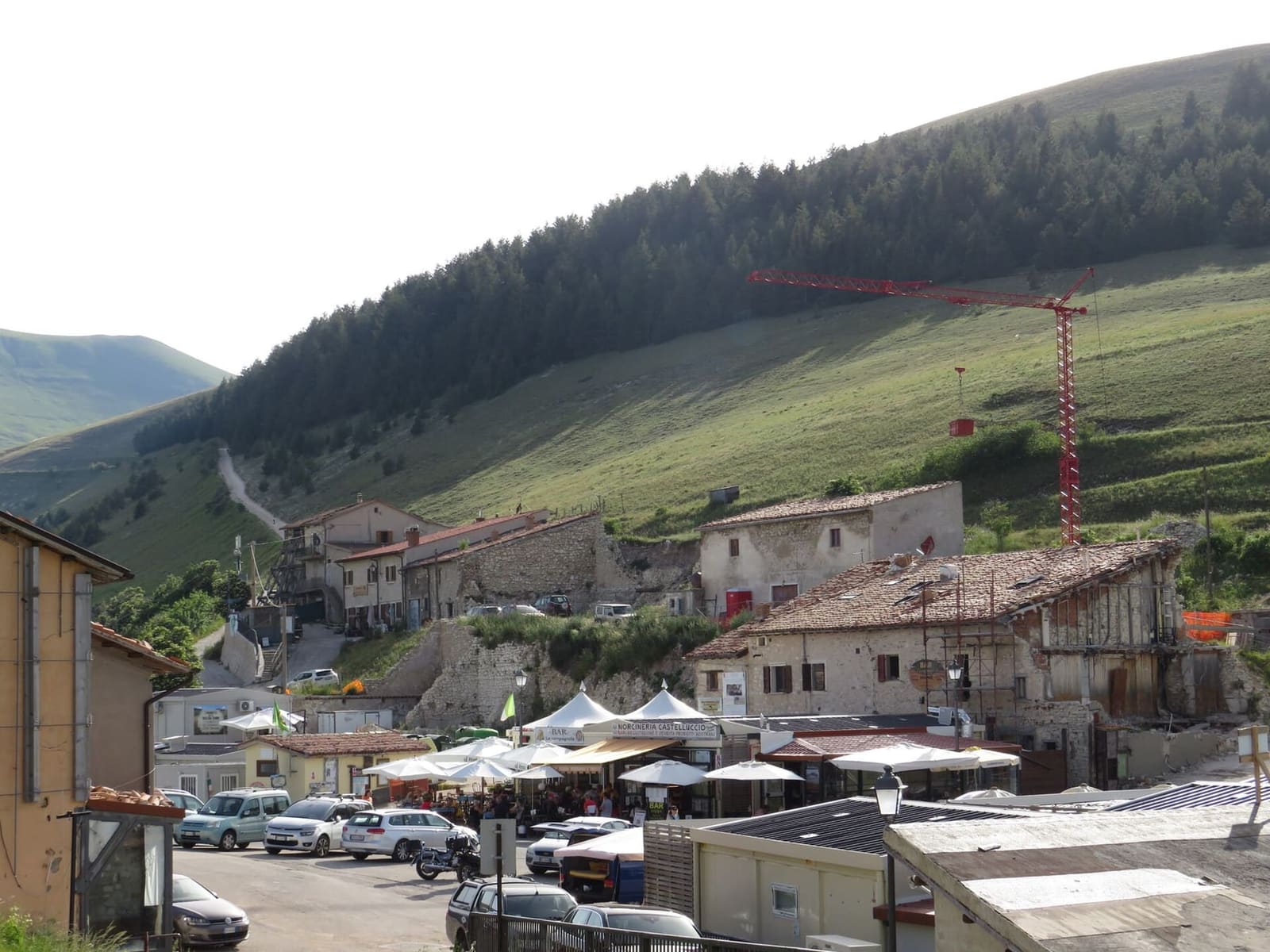 die Häuser von Castelluccio, die Verkaufsstände und der Kran des Wiederaufbaus, im Juni 2022