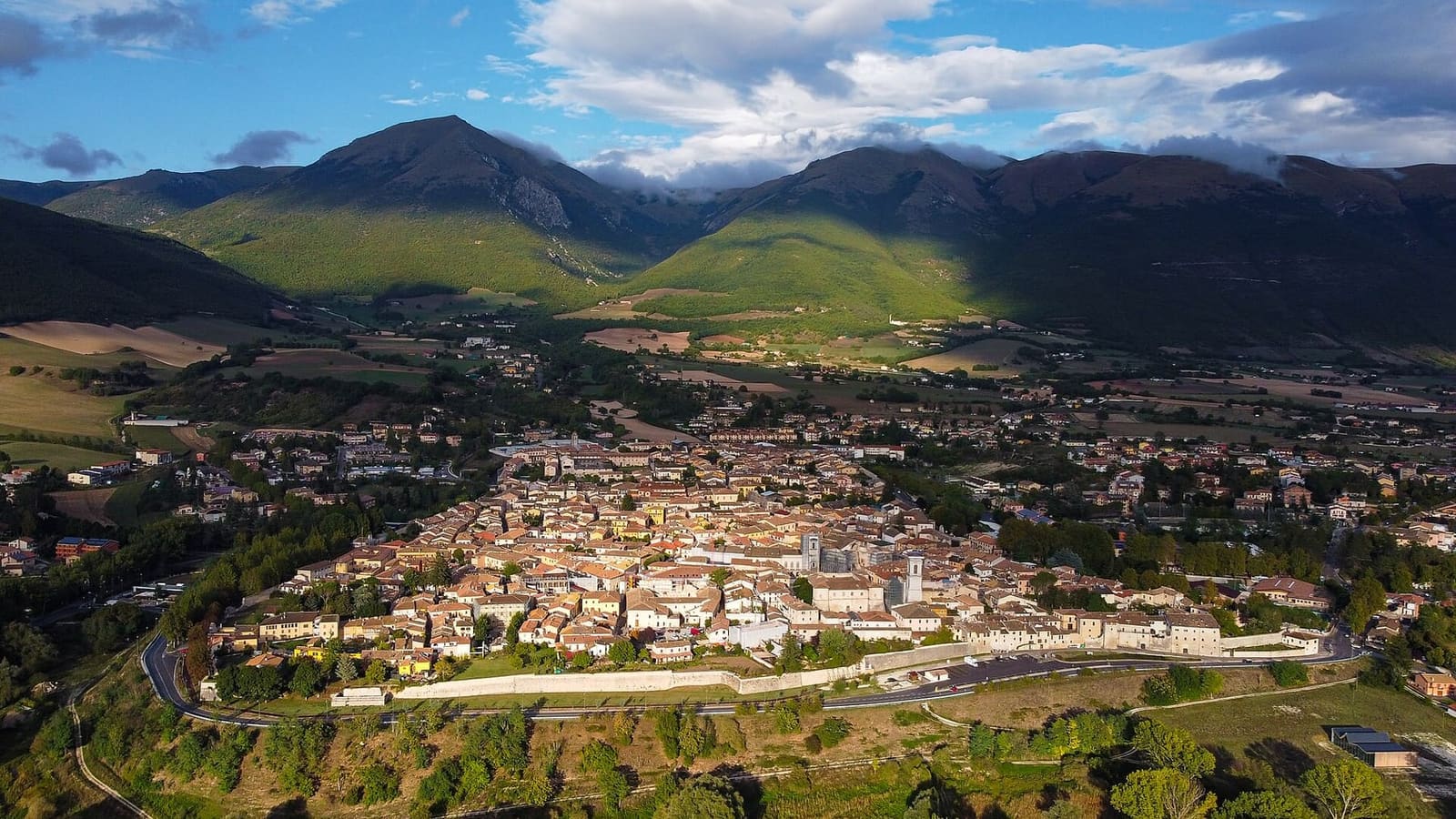 Norcia von oben, von seinen Mauern umschlossen, vor den Sibillinischen Bergen, im September 2020