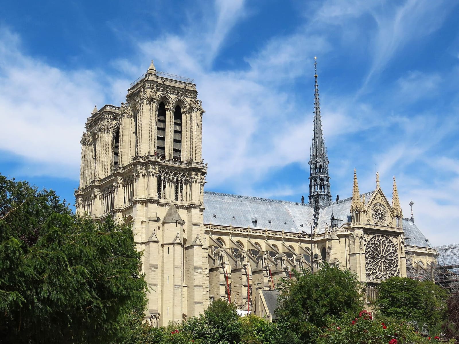 die Seite von Notre-Dame mit dem wiederaufgebauten Vierungsturm und der Südrose, vom Square René-Viviani aus