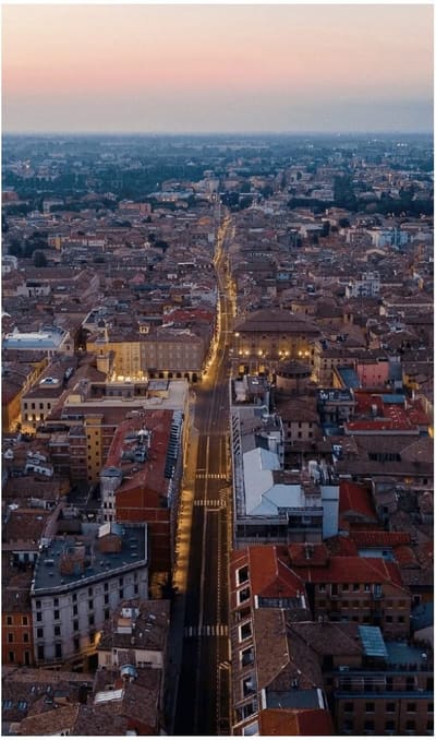 i tetti del centro dall'alto al tramonto, con la strada dritta che taglia la città verso la pianura