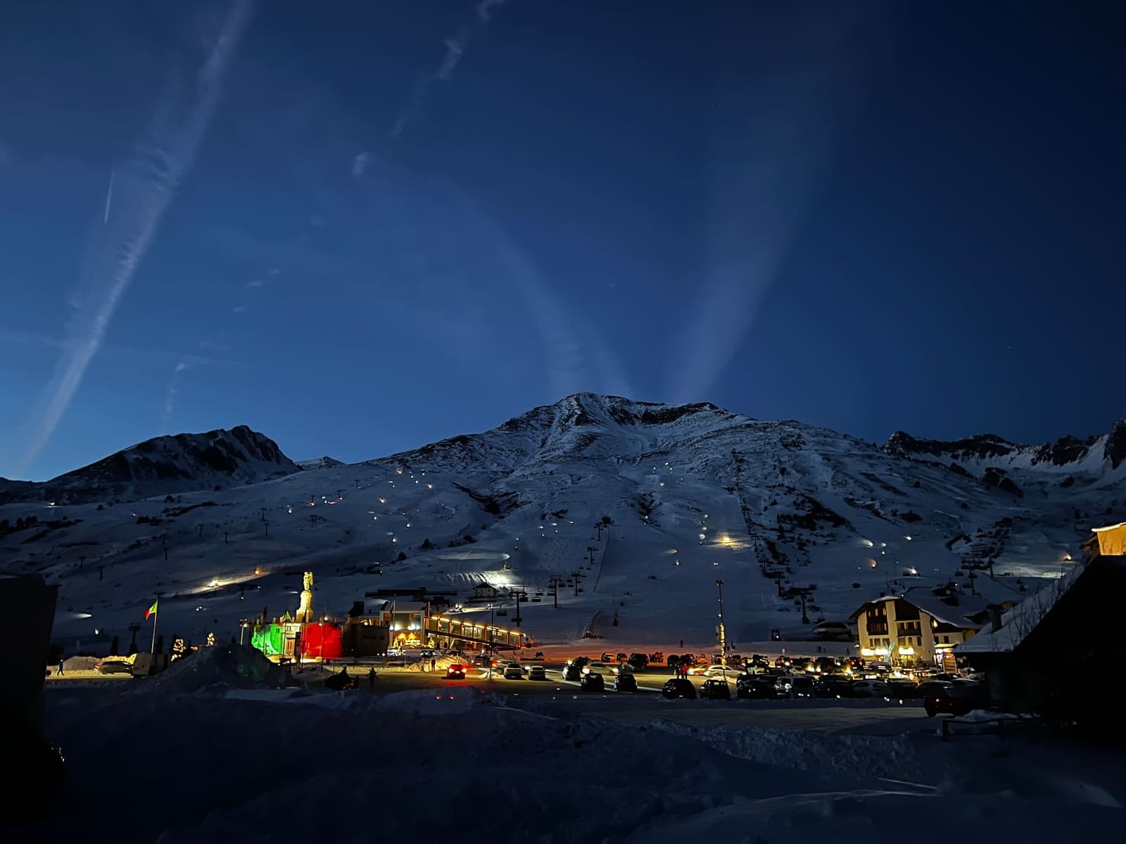 scatto dal camper: il Passo del Tonale di notte, il sacrario illuminato di verde e rosso e le luci delle piste