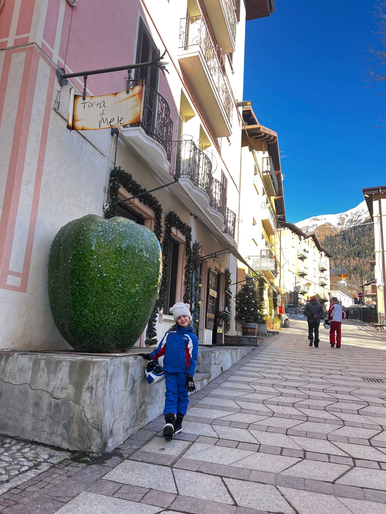 nostra figlia accanto alla mela verde di mosaico, sotto l'insegna della torta di mele