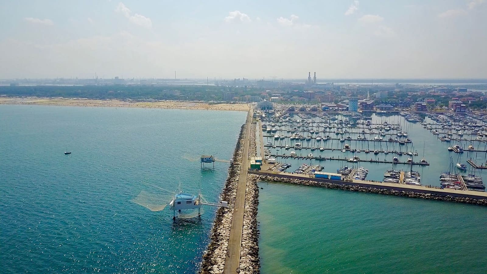 la diga di Marina di Ravenna dall'alto, con un capanno da pesca e il porto turistico