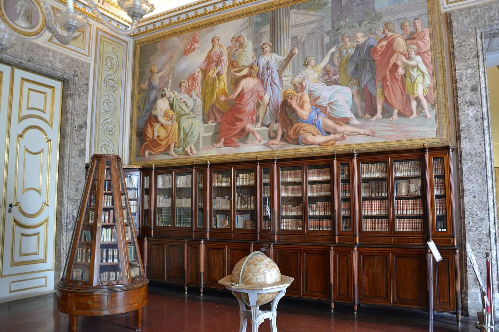 la bibliothèque palatine avec les fresques au-dessus des rayonnages et un globe