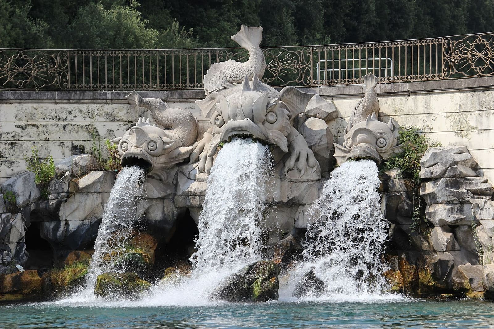 les dauphins de pierre de la fontaine des Dauphins qui crachent l'eau dans le bassin