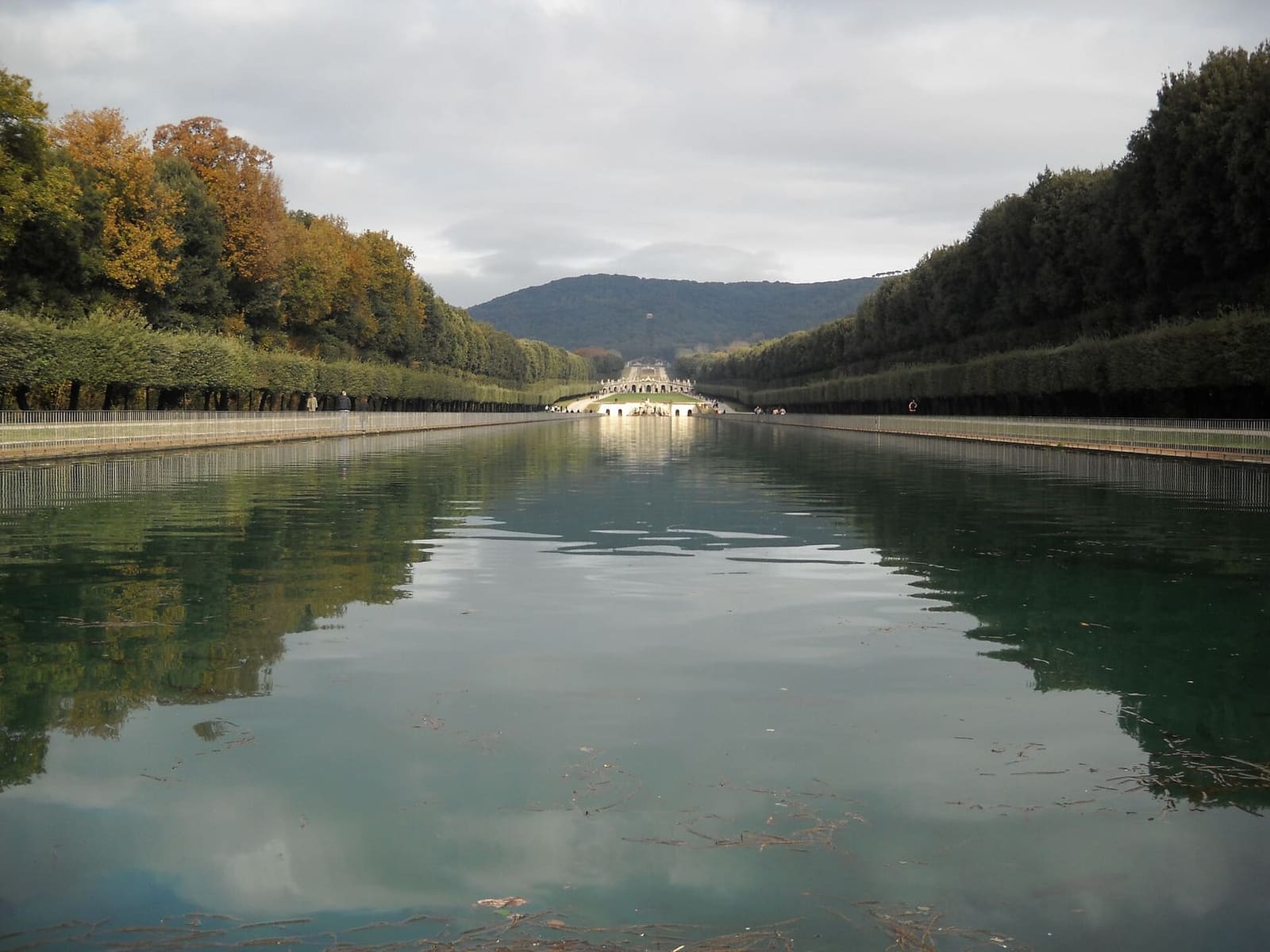 la Via d'Acqua avec les arbres d'automne reflétés dans le bassin et la cascade au fond