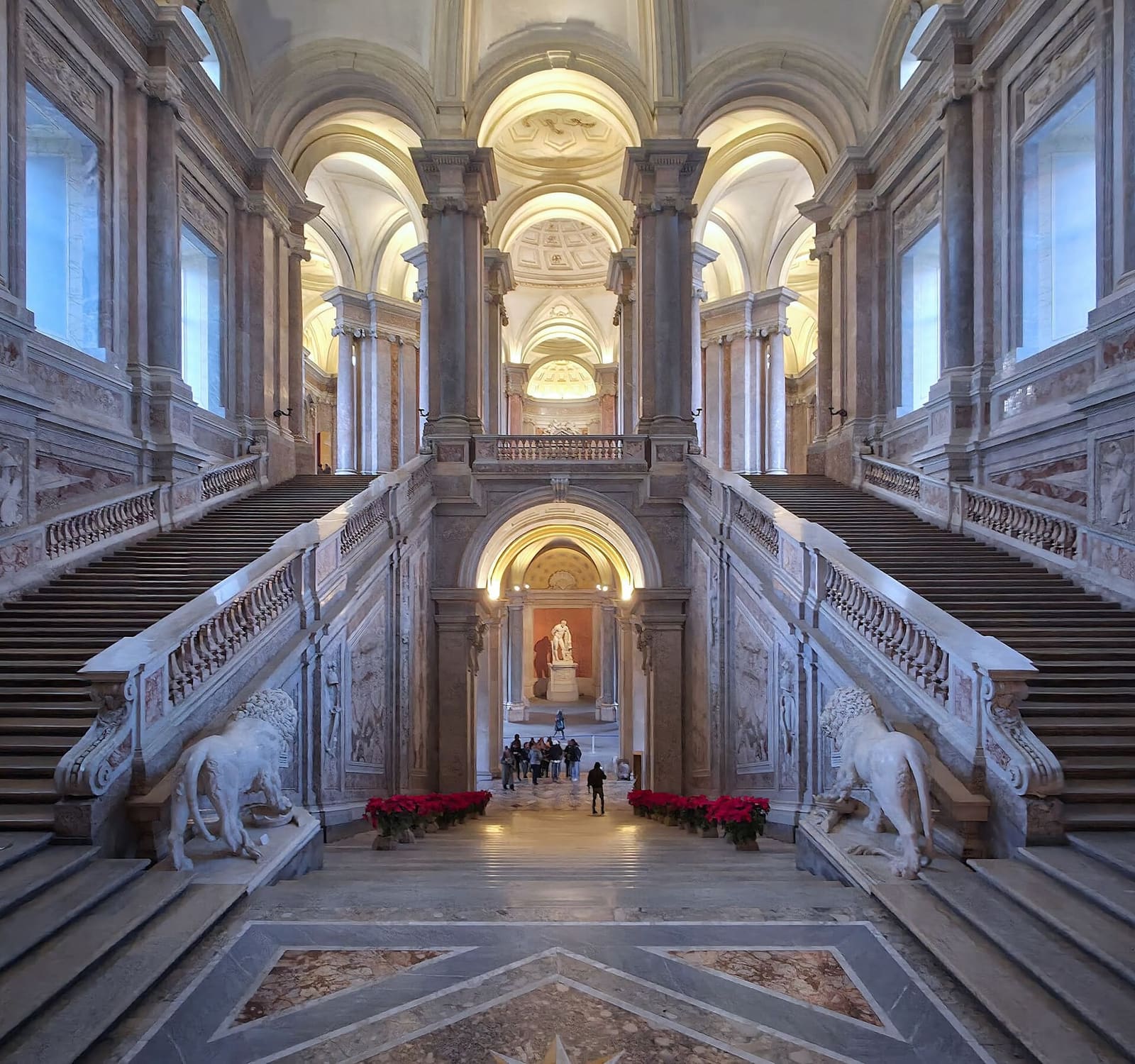 le grand escalier d'honneur avec ses deux lions de marbre et des poinsettias au pied des marches