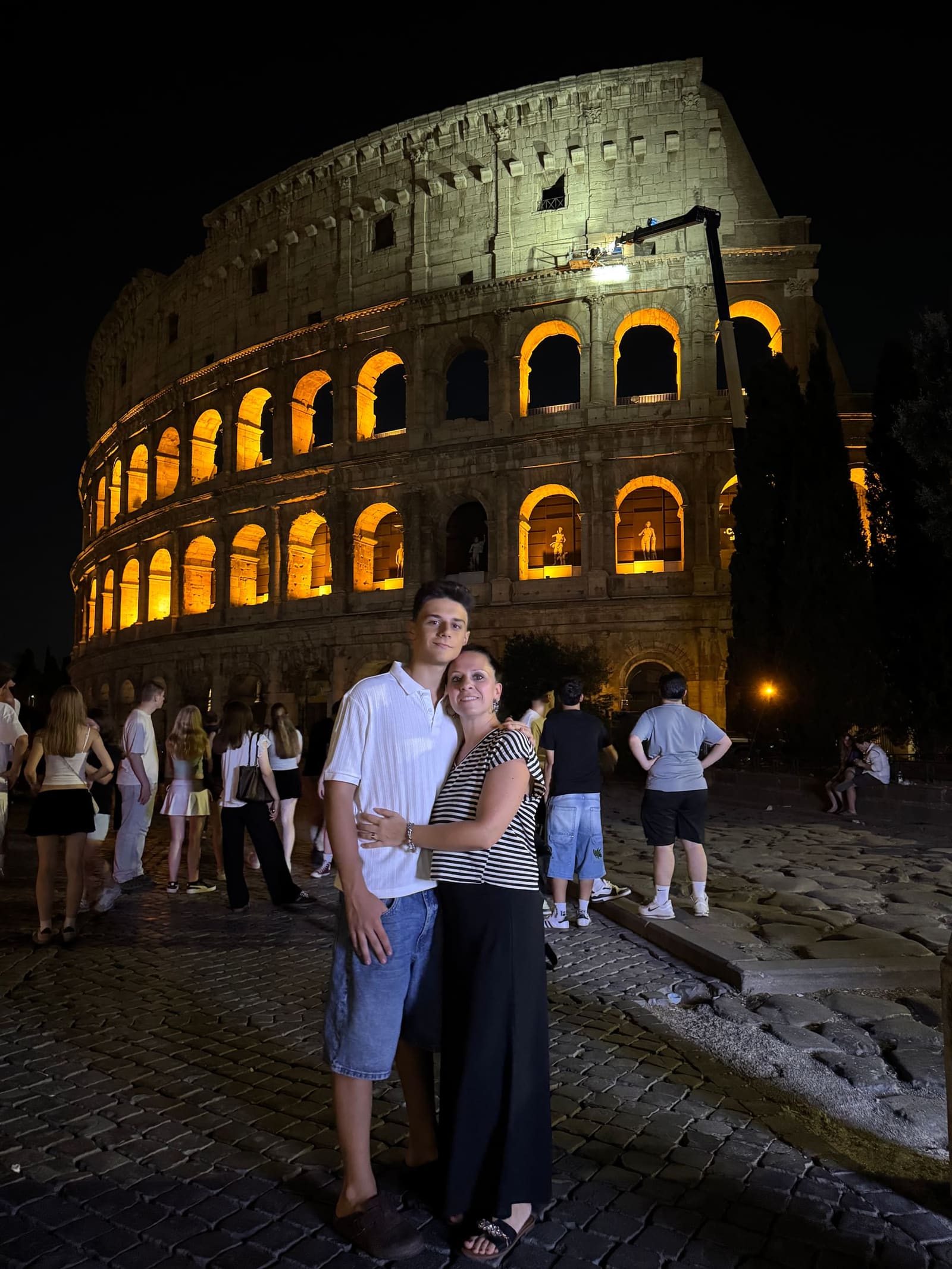 Gabriele e Marcella davanti al Colosseo acceso, in mezzo alla gente che a quell'ora è ancora tutta lì