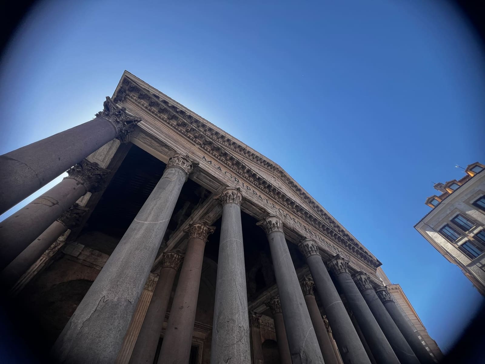 il pronao del Pantheon preso dal basso, con le colonne di granito che convergono verso il cielo