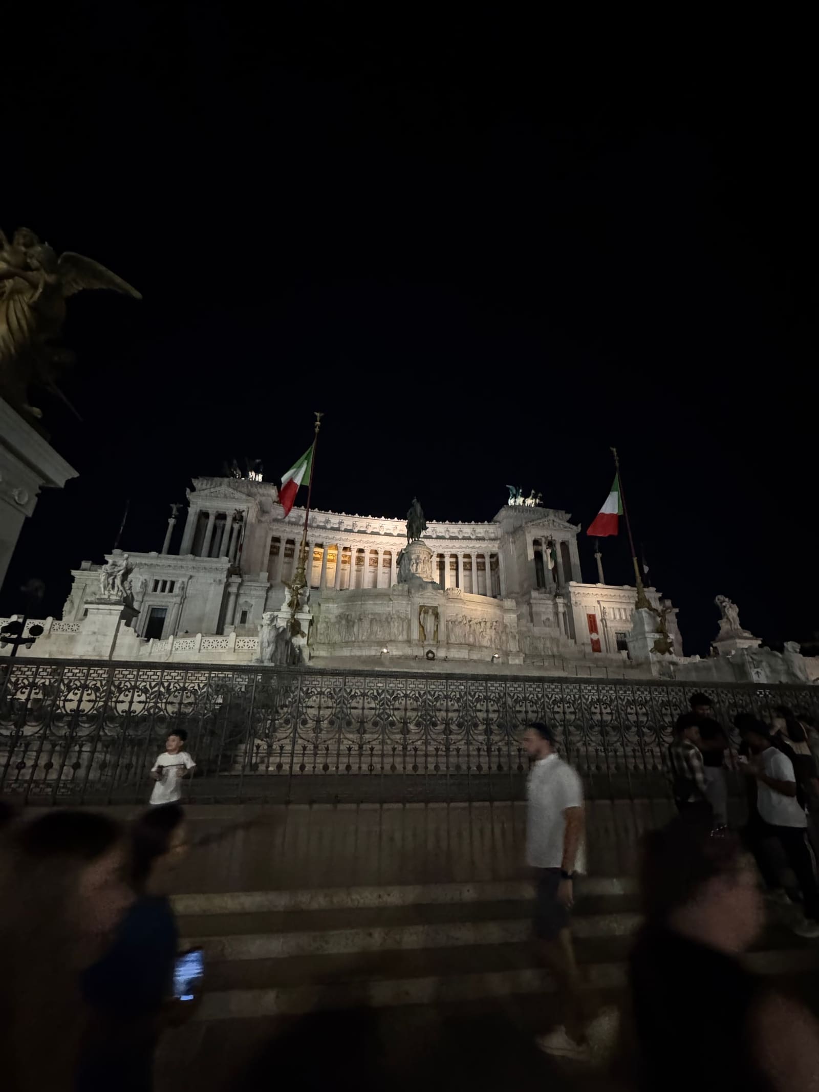 il Vittoriano dalla scalinata, con le bandiere ai lati e la gente che sale e scende in controluce