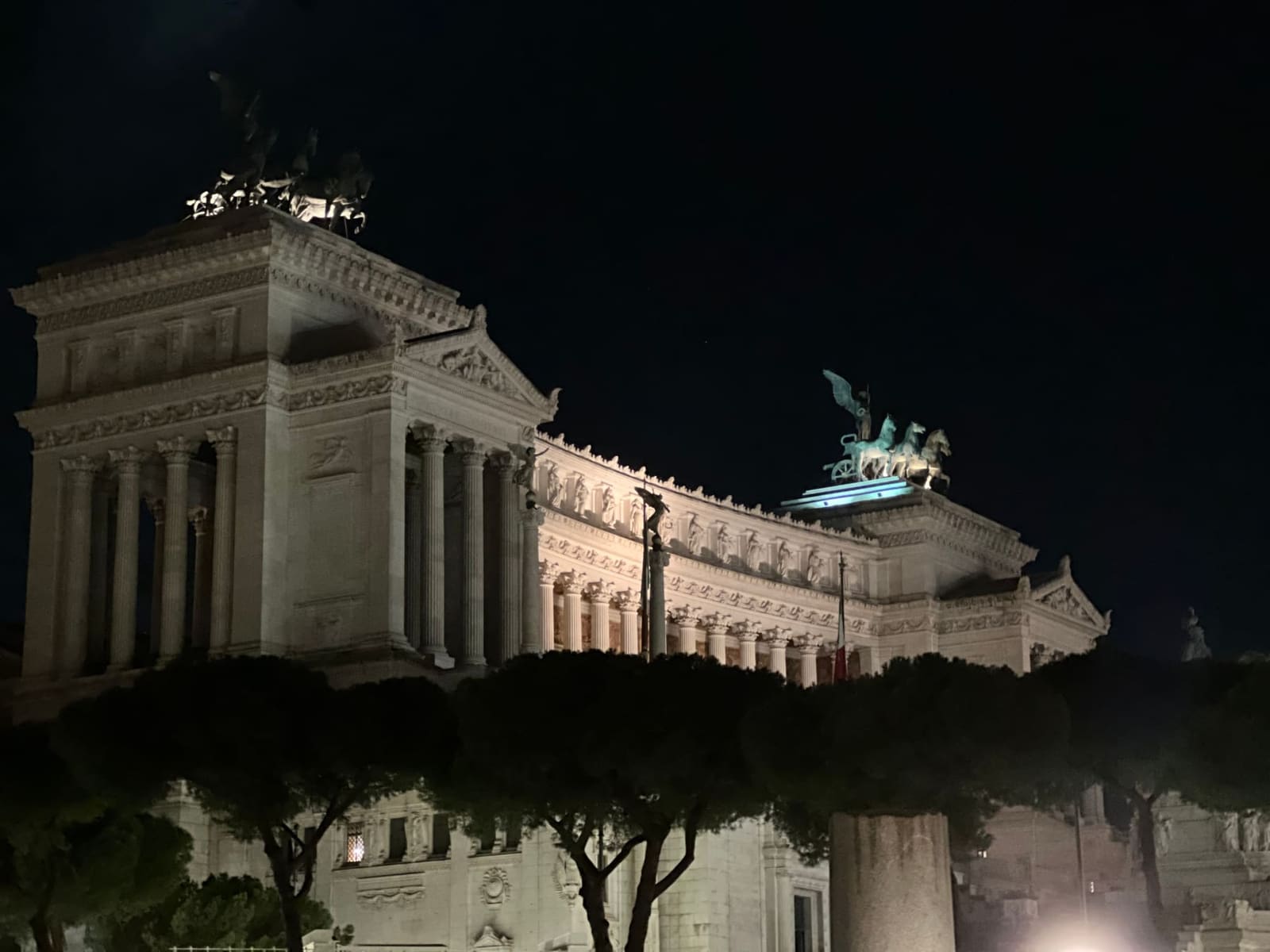 il Vittoriano di sera dal lato, con le quadrighe di bronzo sul cornicione contro il cielo nero