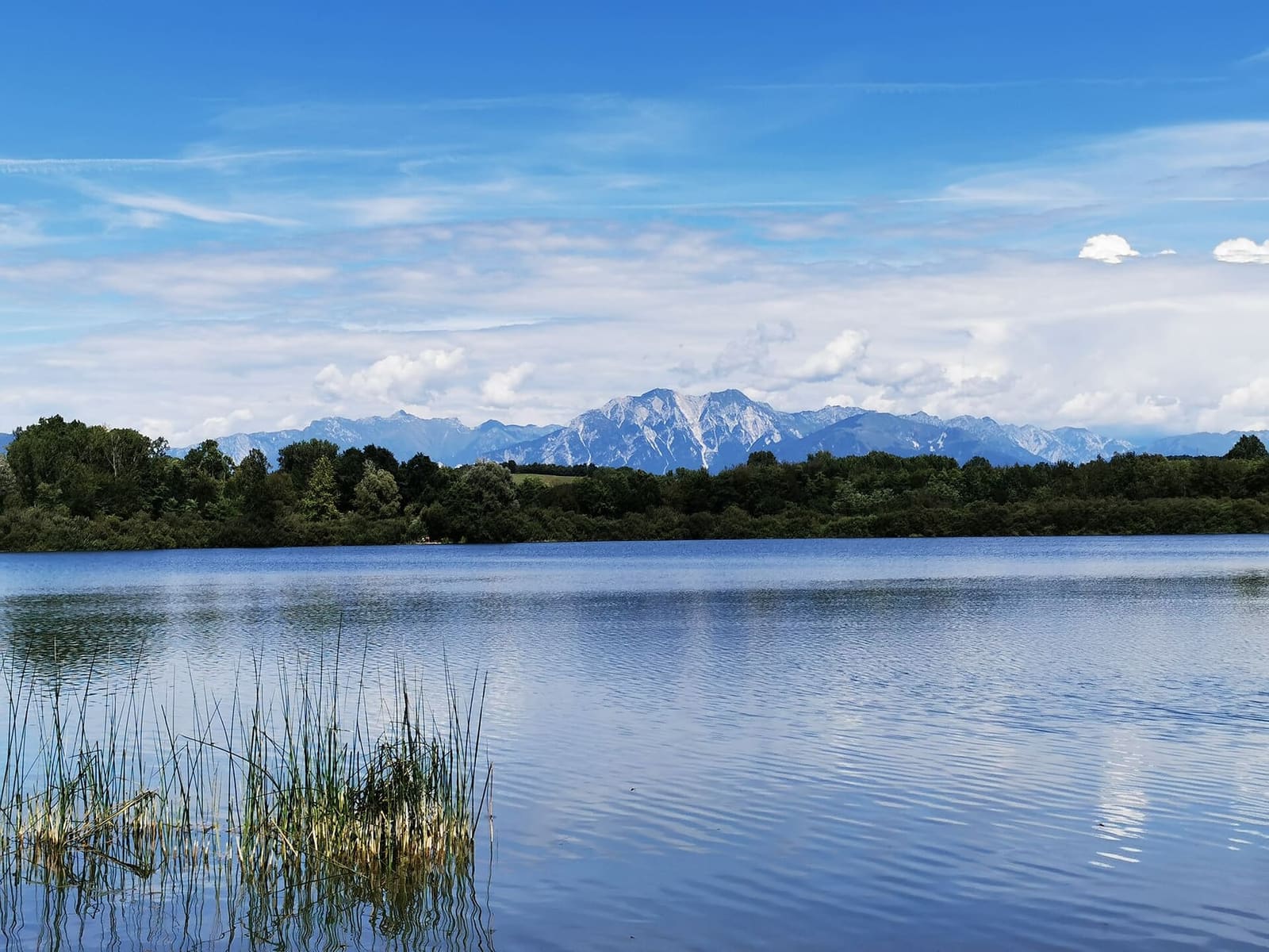 il lago di Ragogna nell'anfiteatro morenico, con le montagne all'orizzonte