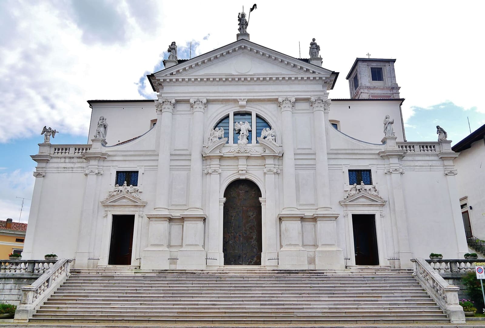 la facciata bianca del Duomo di San Michele Arcangelo in cima alla scalinata